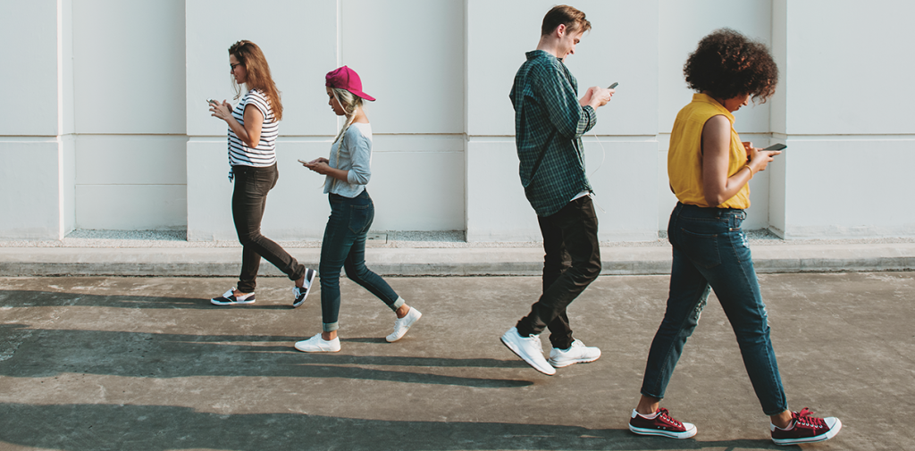 pessoas caminhando com celular na mão, exemplo de conceito de sociedade 5.0