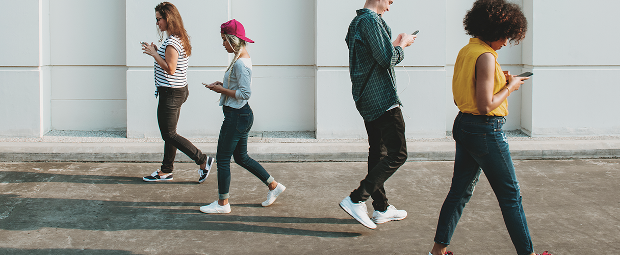pessoas caminhando com celular na mão, exemplo de conceito de sociedade 5.0